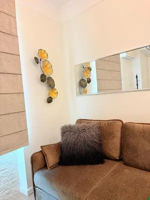 a living room with a brown couch and a mirror at Vilnius Symphony Apartments in Vilnius
