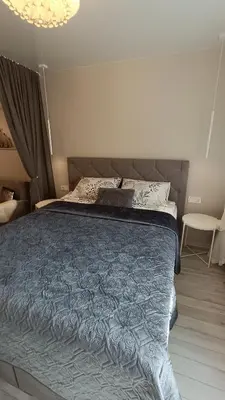 a bedroom with a large bed with a blue comforter at MEŠKUTĖS APARTAMENTAI in Druskininkai