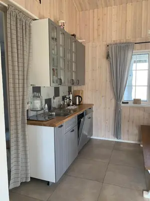 a kitchen with white cabinets and a sink and a window at Pirties namelis Paliekys in Lekėčiai