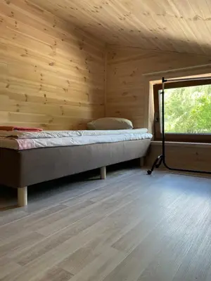 a bedroom with a bed in a wooden wall at Atostogų namelis in Kurėnai