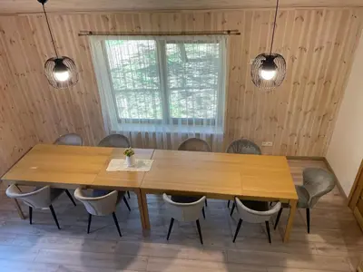 a dining room with a wooden table and chairs at Atostogų namelis in Kurėnai