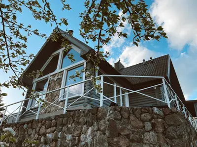 a house on top of a stone wall at HYTTE - Cozy Stay For Families & Friends in Jagėlonys Kalniniai