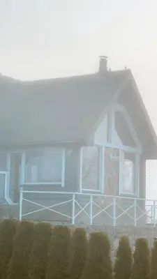 a large house with a blue porch at HYTTE - Cozy Stay For Families & Friends in Jagėlonys Kalniniai