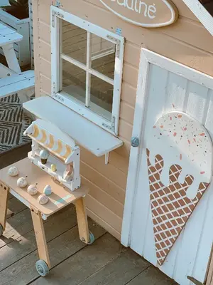 a playhouse with a table and a chair next to a door at HYTTE - Cozy Stay For Families & Friends in Jagėlonys Kalniniai