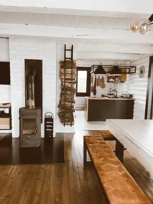a living room with a stove and a kitchen at HYTTE - Cozy Stay For Families & Friends in Jagėlonys Kalniniai