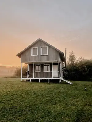 a house sitting on top of a grass field at HYGGE Sauna&Fishing House in Jagėlonys Kalniniai