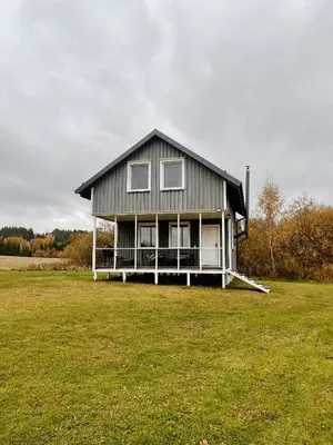 a large house on a grassy field with at HYGGE Sauna&Fishing House in Jagėlonys Kalniniai
