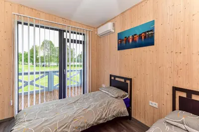 a bedroom with a bed and a large window at Sodyba Svayos in Zarasai