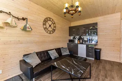 a living room with a couch and a kitchen at Sodyba Svayos in Zarasai