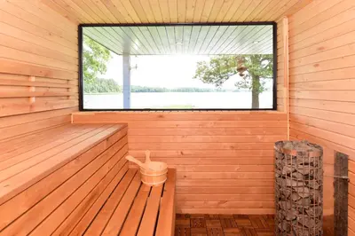 a sauna with a window and a trash can at Sodyba Svayos in Zarasai