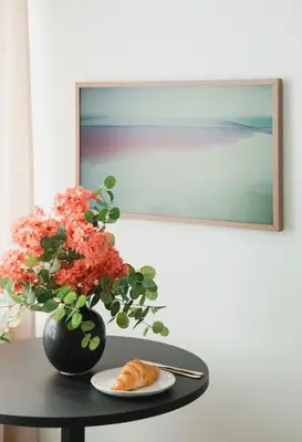 a table with a vase of flowers and a plate of food at Apartment in Žvėrynas in Vilnius