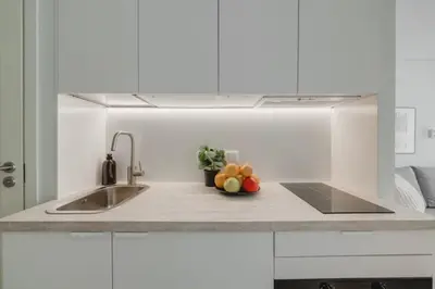 a kitchen with a sink and a bowl of fruit at Apartment in Žvėrynas in Vilnius