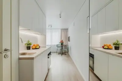 a kitchen with white cabinets and oranges on the counters at Apartment in Žvėrynas in Vilnius