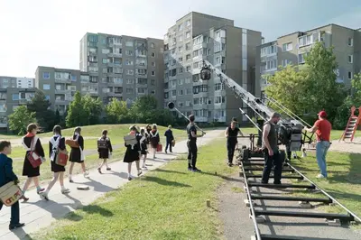 a group of people are standing in a field with a telescope at Šeškinės 61 Spacious Cozy Apartment in Vilnius