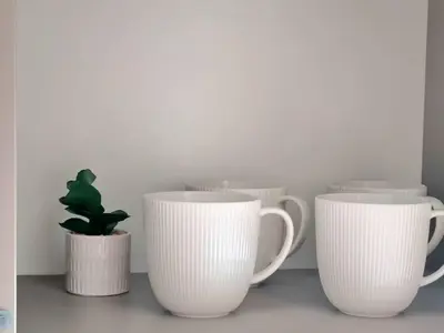 a row of white coffee cups with a cactus at ALEGRE apartment in Druskininkai