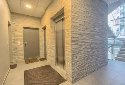 a lobby with a brick wall and a door at ALEGRE apartment in Druskininkai