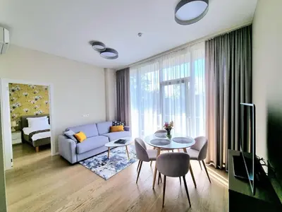 a living room with a table and a couch at ALEGRE apartment in Druskininkai
