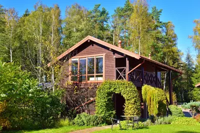 a log cabin in the woods with a garden at Bebrusų sodyba in Molėtai