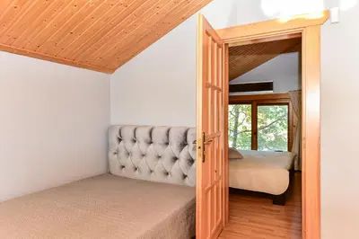 a bedroom with a bed and an open door at Bebrusų sodyba in Molėtai