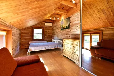 a room with a bed in a wooden cabin at Bebrusų sodyba in Molėtai