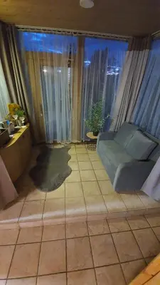 a living room with a couch and a large window at Kaimo turizmo sodyba Geras in Leliūnai