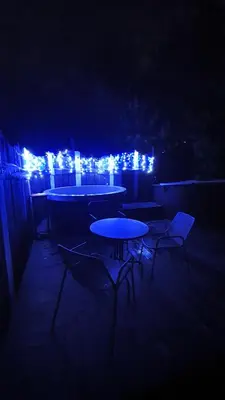 a group of tables and chairs at night with lights at Kaimo turizmo sodyba Geras in Leliūnai
