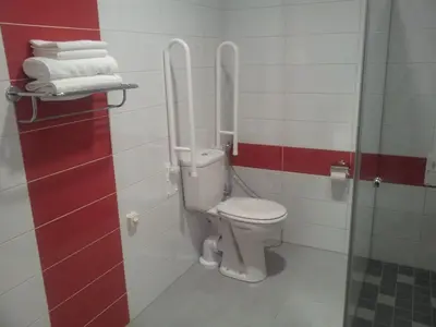 a bathroom with a toilet with red and white tiles at Algiro Hotel in Kaunas