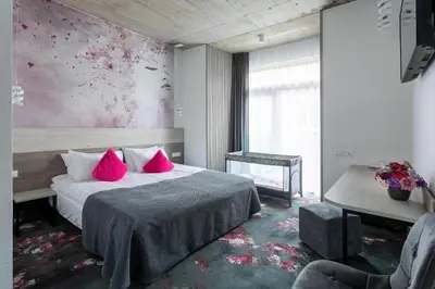 a bedroom with a large bed with pink pillows at Algiro Hotel in Kaunas