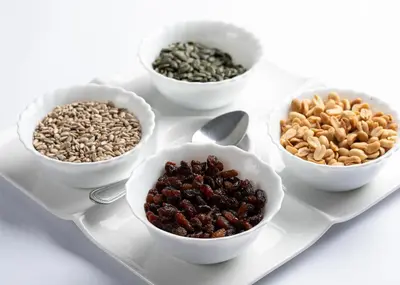 four bowls of nuts and seeds on a plate at Algiro Hotel in Kaunas