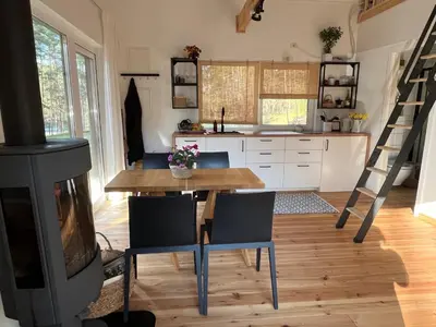 a kitchen with a table and chairs and a stove at Namelis Strazdas in Molėtai