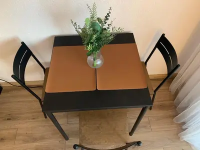 a table with a vase of flowers on it at Cozy Two Room Apartment near city centre in Alytus