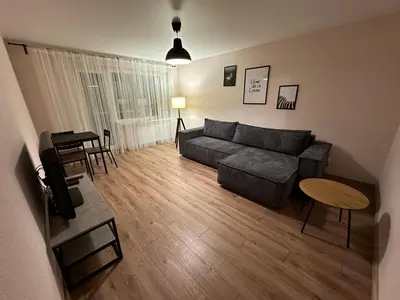 a living room with a couch and a table at Cozy Two Room Apartment near city centre in Alytus