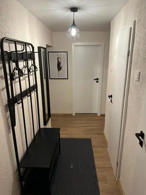 a hallway with a black bench and a white door at Cozy Two Room Apartment near city centre in Alytus