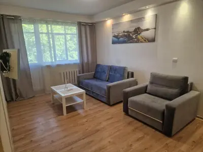 a living room with a couch and a chair and a table at Butas 34 in Šiauliai