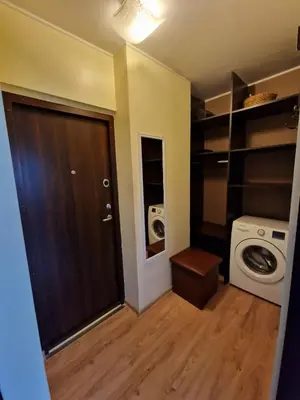 a small bathroom with a washing machine and a door at Butas 34 in Šiauliai