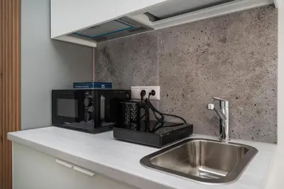 a kitchen counter with a sink and a microwave at Studios K1A in Vilnius