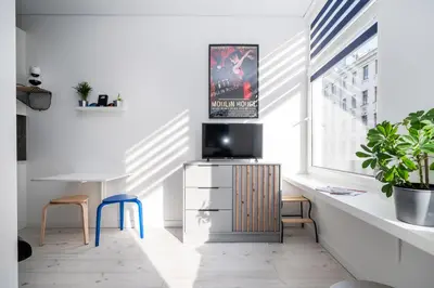 a living room with a tv on a cabinet and a window at Studios K1A in Vilnius