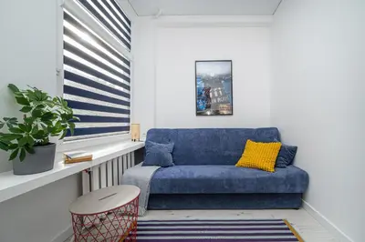 a blue couch in a room with a window at Studios K1A in Vilnius