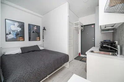 a bedroom with a bed next to a sink at Studios K1A in Vilnius