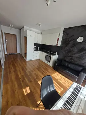 an empty living room with a couch and a kitchen at The cosiest apartment in Vilnius in Vilnius