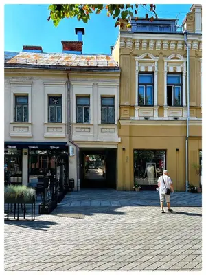 an older man walking in front of a building at Apartaments in the city centre in Kaunas