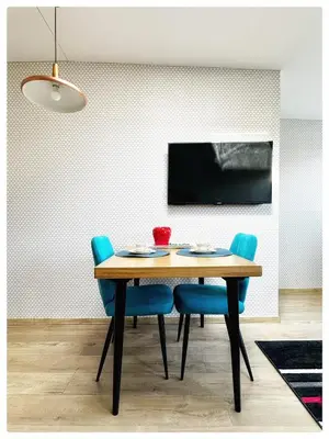 a dining room with a table and blue chairs at Apartaments in the city centre in Kaunas