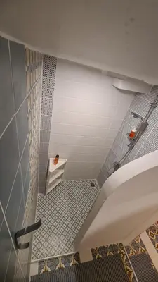 a bathroom with a toilet and a tile floor at Tiki Taka Hostel & Pub in Vilnius