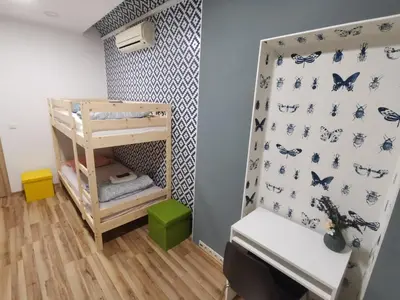 a small room with a bunk bed and a desk at Tiki Taka Hostel & Pub in Vilnius