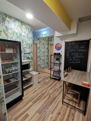 a room with a refrigerator and a table in it at Tiki Taka Hostel & Pub in Vilnius