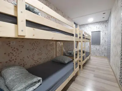 a bunk bed in a room with wooden bunk beds at Tiki Taka Hostel & Pub in Vilnius