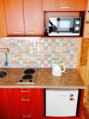a kitchen counter with a microwave and a sink at A Cozy Central Studio in Druskininkai