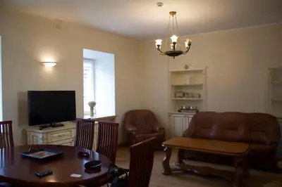 a living room with a couch and a table and a television at Cottage in old town in Vilnius