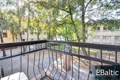 a balcony with a fence and trees and a building at Cottage in old town in Vilnius