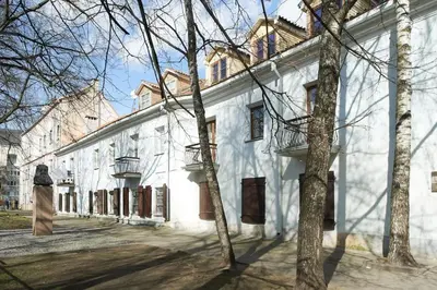 a white building with trees in front of it at Cottage in old town in Vilnius